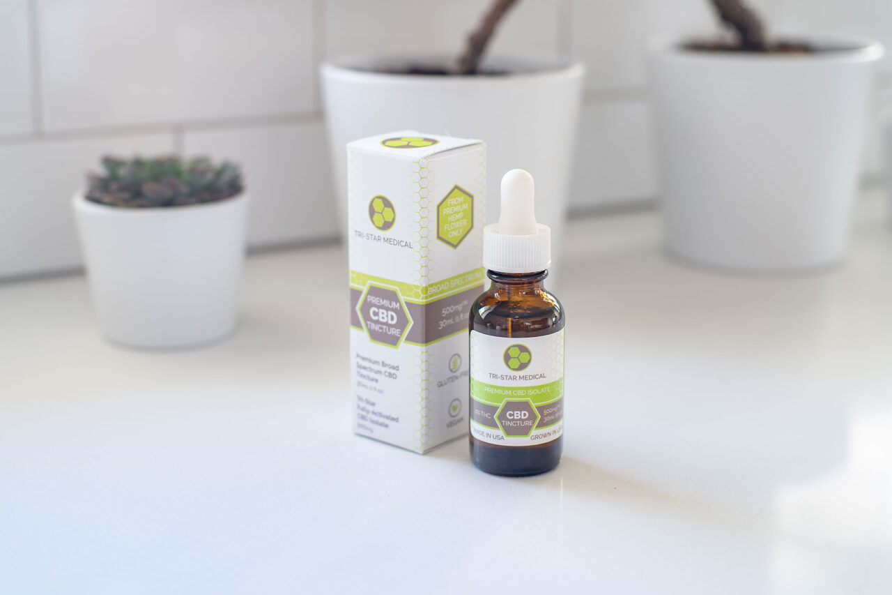 Image of Tri-Star Medical's THC-Free Broad Spectrum Tincture bottle and box on a beautiful white counter in a sunlit kitchen.